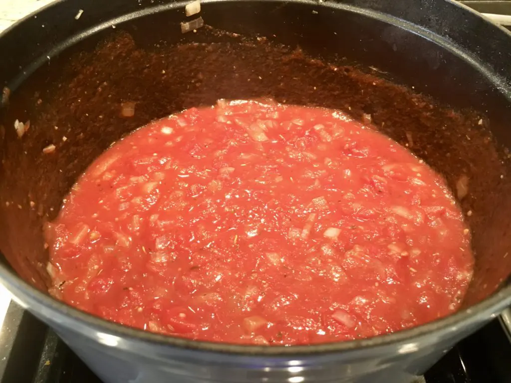 healthier lasagna recipe simmering pasta sauce on the stove in a staub pot