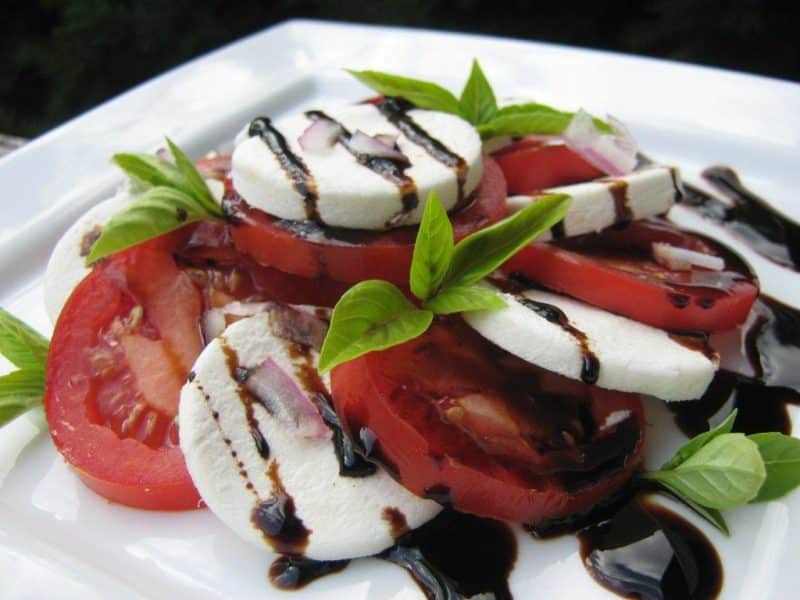 Classic caprese salad on a white plate.