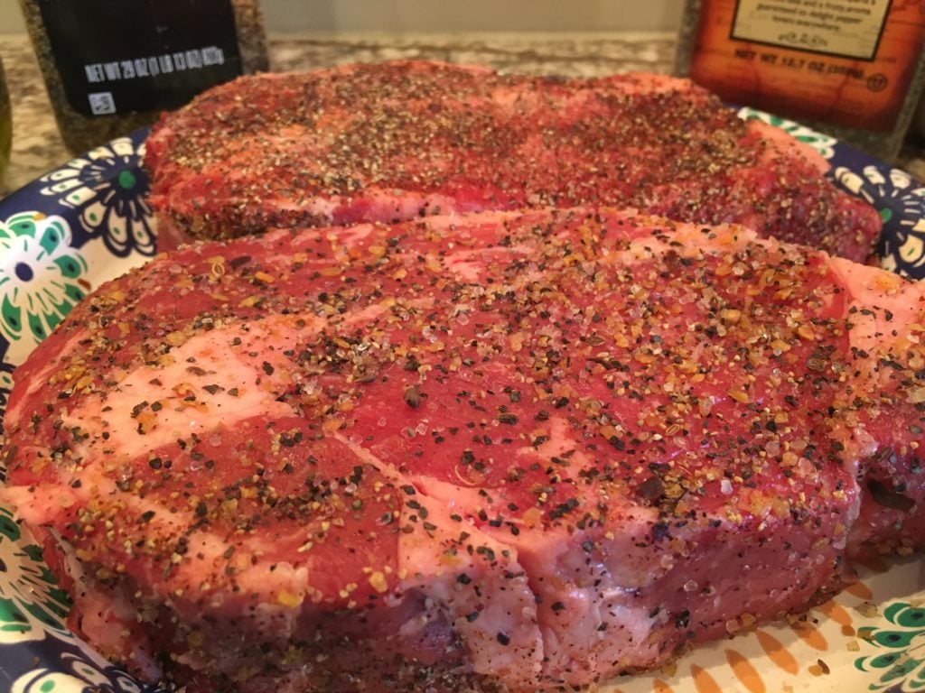 uncooked ribeye steaks.