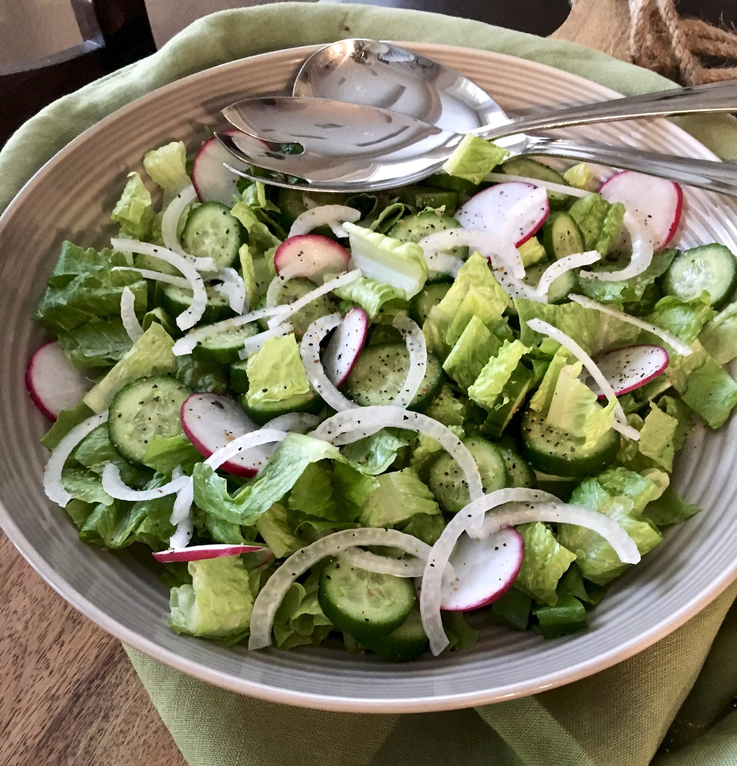 romaine salad with Persian cucumbers, radishes, and white onions in a bowl