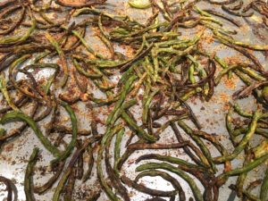 roasted green beans on a foil lined baking sheet.