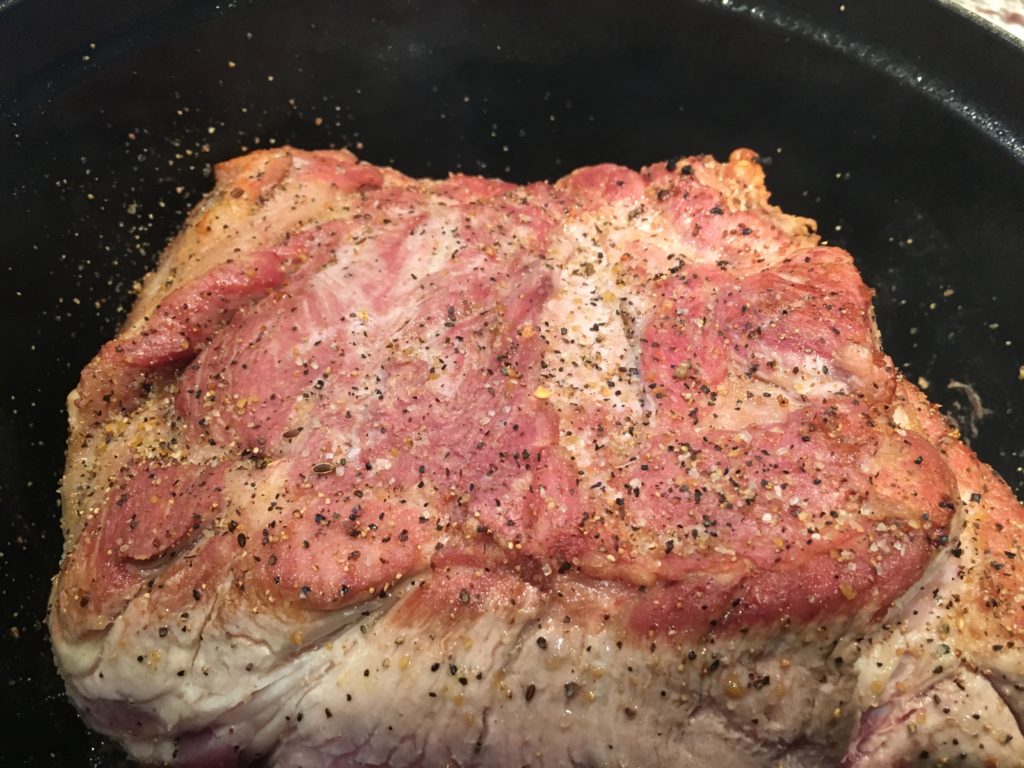 searing the pork roast in a heavy pan