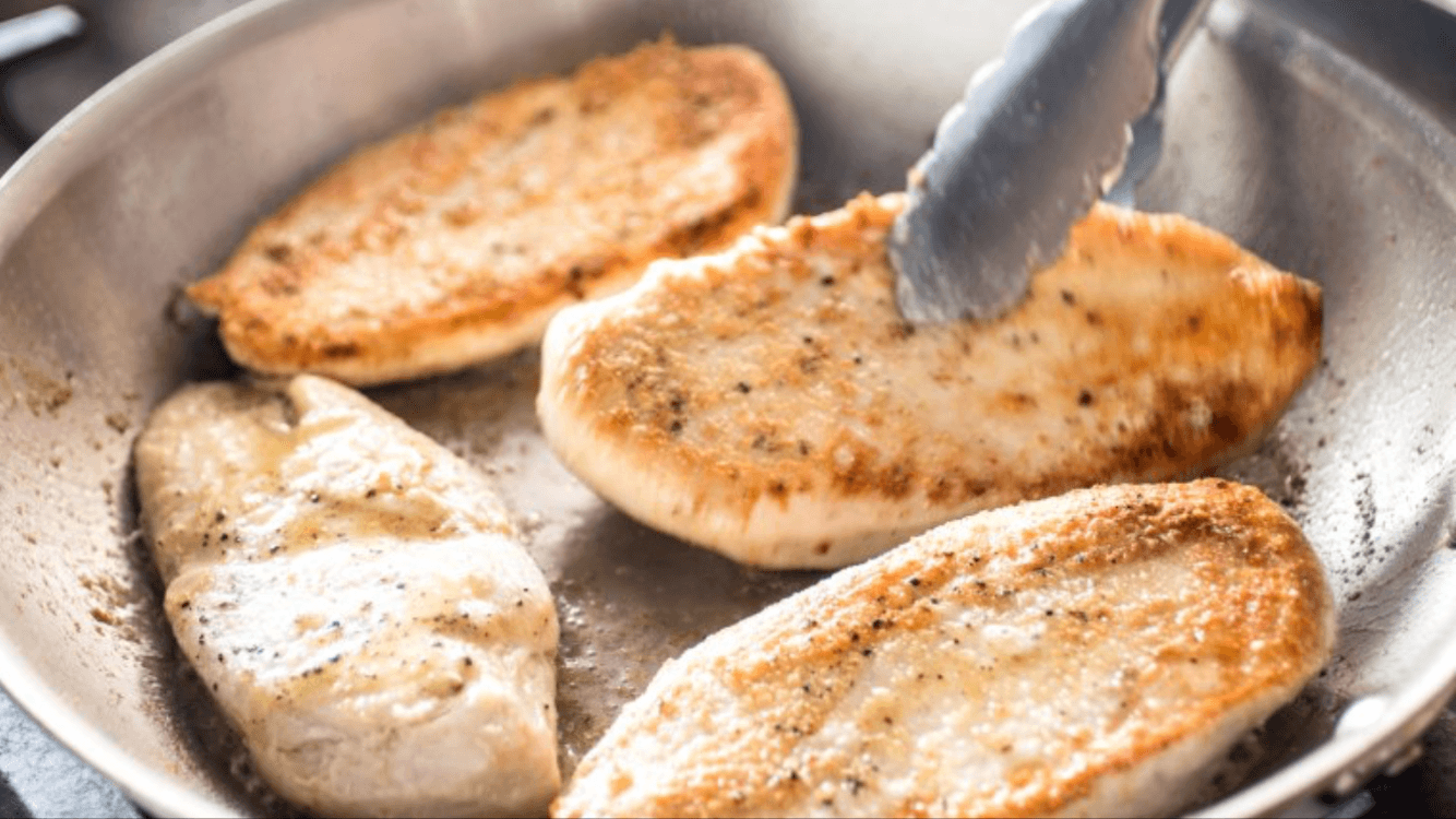 searing chicken cutlets in a skillet.