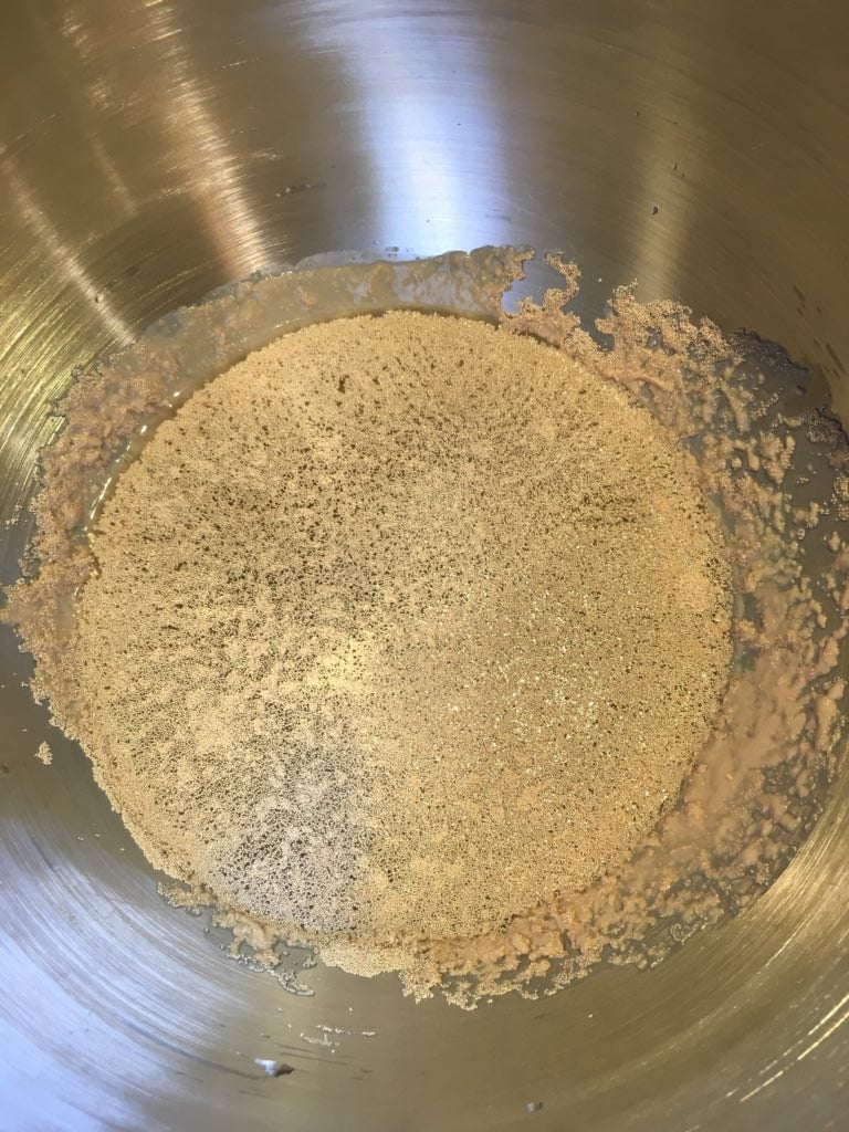 Mixing the water, yeast, and sugar in a mixing bowl