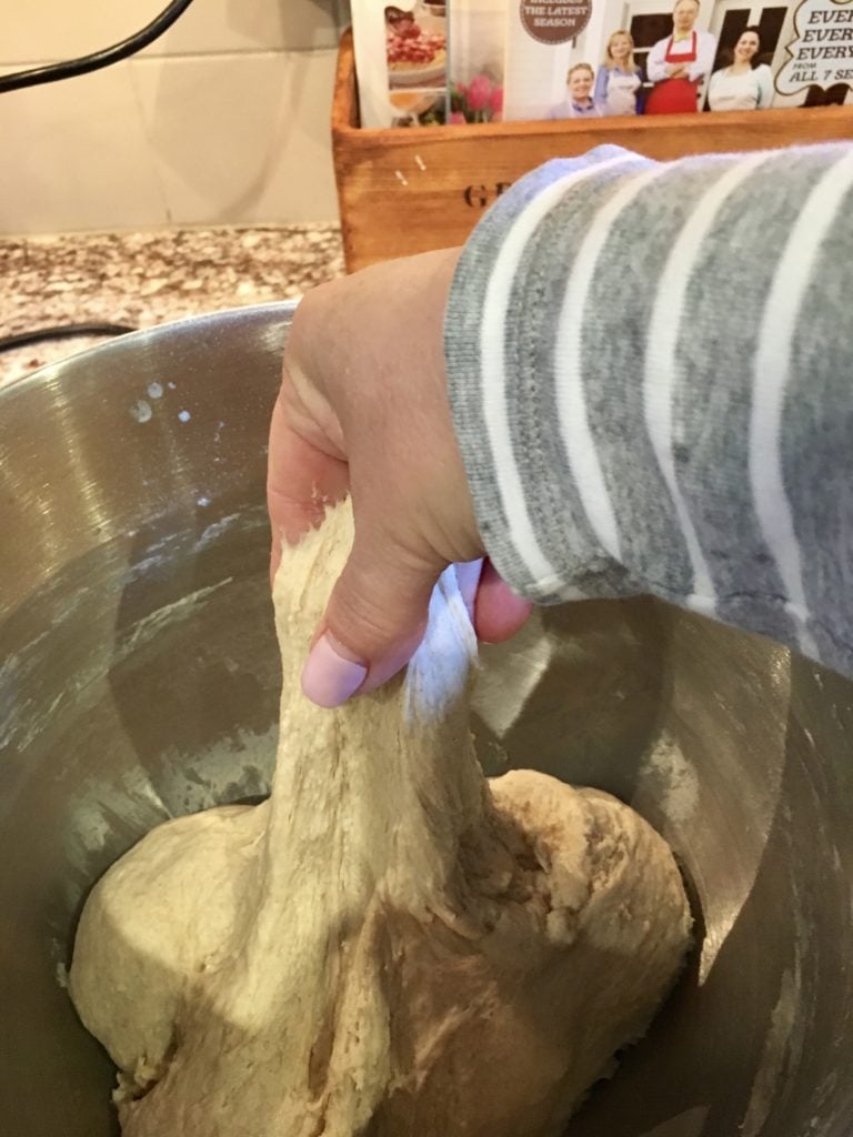 grabbing a handful dough to stretch