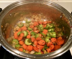 Sauté onions, carrots, and celery, before adding the frozen peas, green beans, and flour in a pot.
