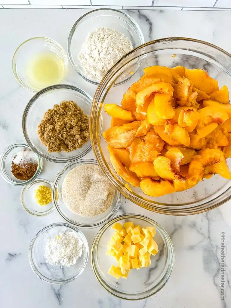 ingredients needed to make peach crisp which contains peaches, granulated sugar, cornstarch, lemon juice, brown sugar, granulated sugar, cinnamon, nutmeg, all purpose flour,  and unsalted butter.