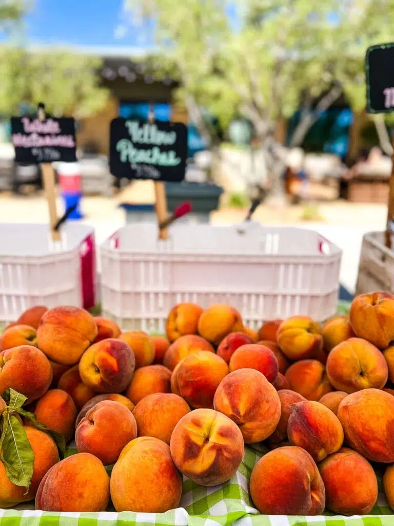 peach displayed on a fruit stand.