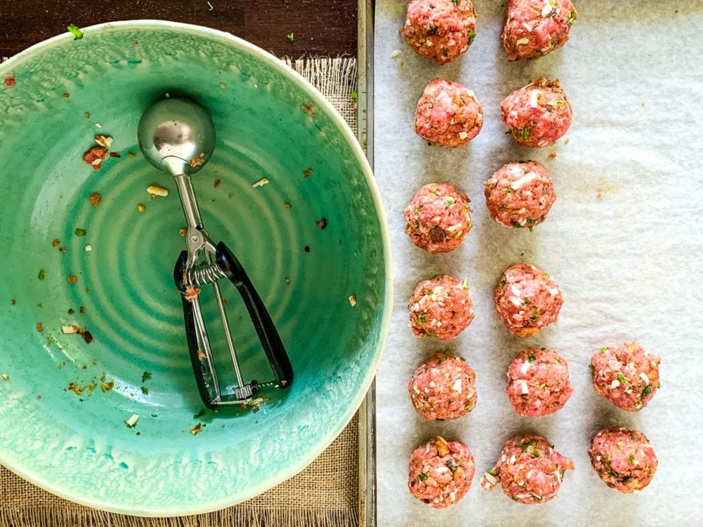 prepping beef and pork meat balls on a baking sheet