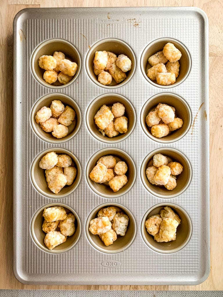 frozen tots placed on the muffin tin