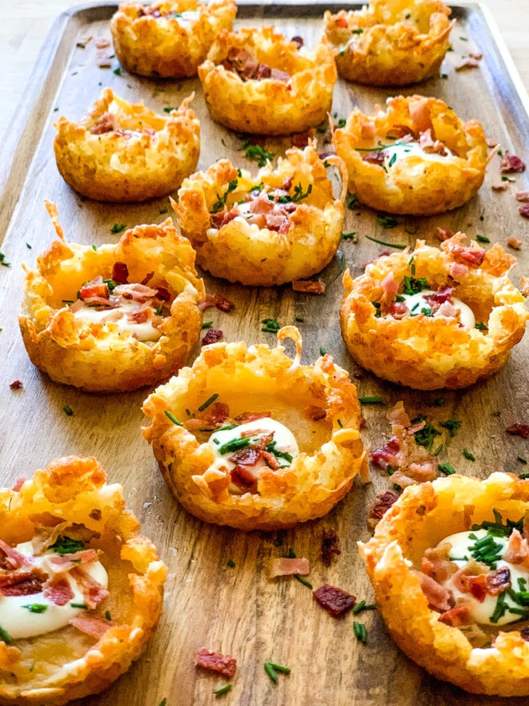 loaded tater tots placed in a wood serving tray.