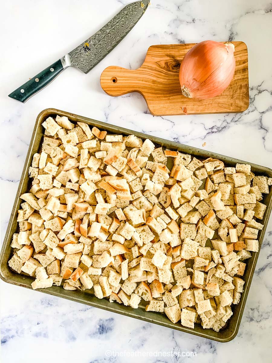 A baking sheet of cubed sourdough bread drying for stuffing.