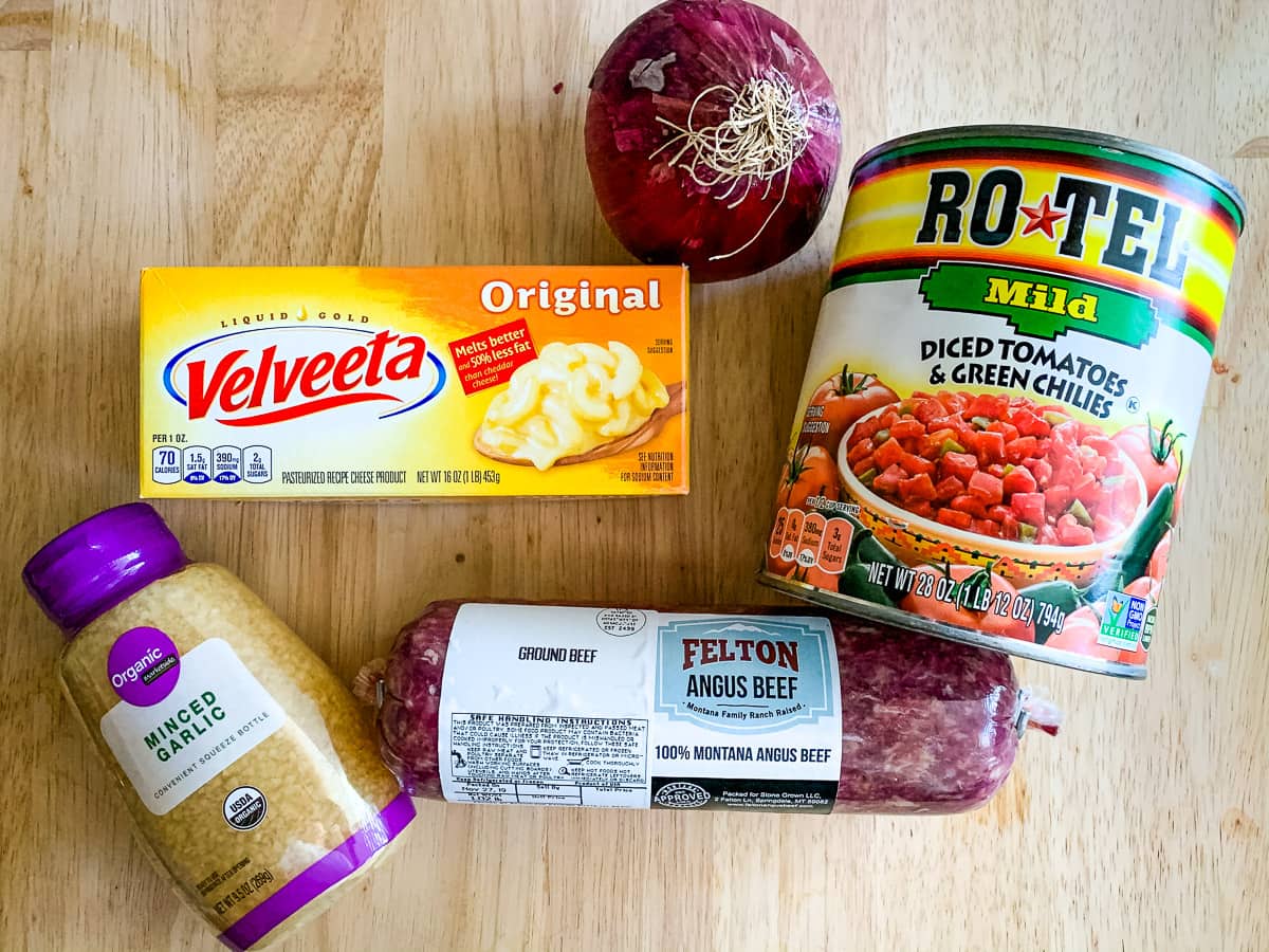 Packages of ground hamburger, Velveeta cheese, Rotel, an onion and minced garlic for keto cheeseburger soup recipe.