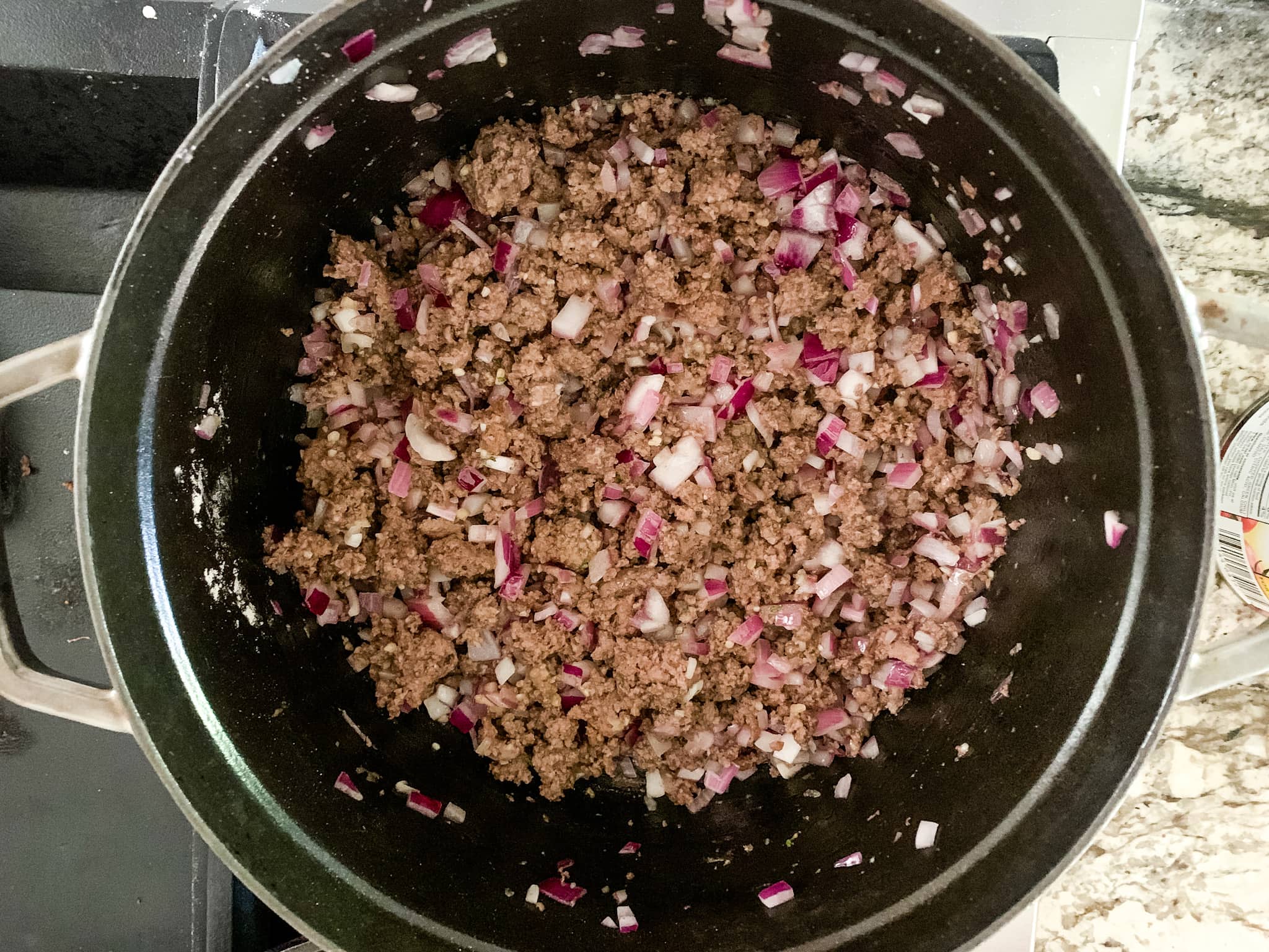 browned ground beef and onions in a pot.