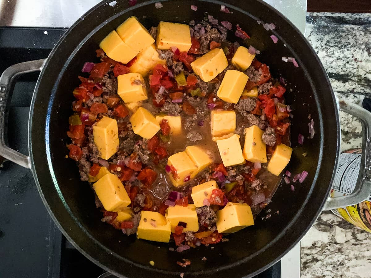 cubes of Velveeta cheese in pot with hamburger soup