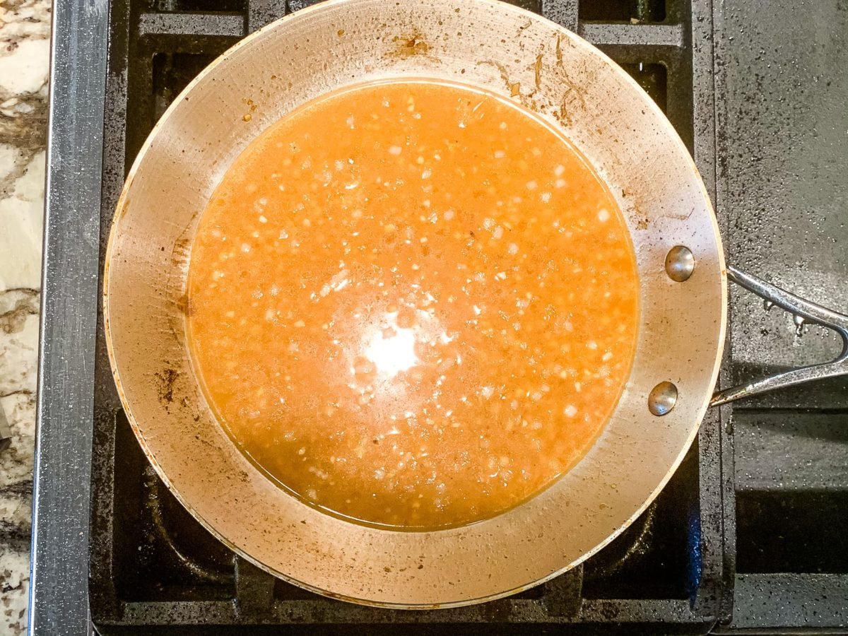 Creamy yellow sauce in a stainless steel skillet.