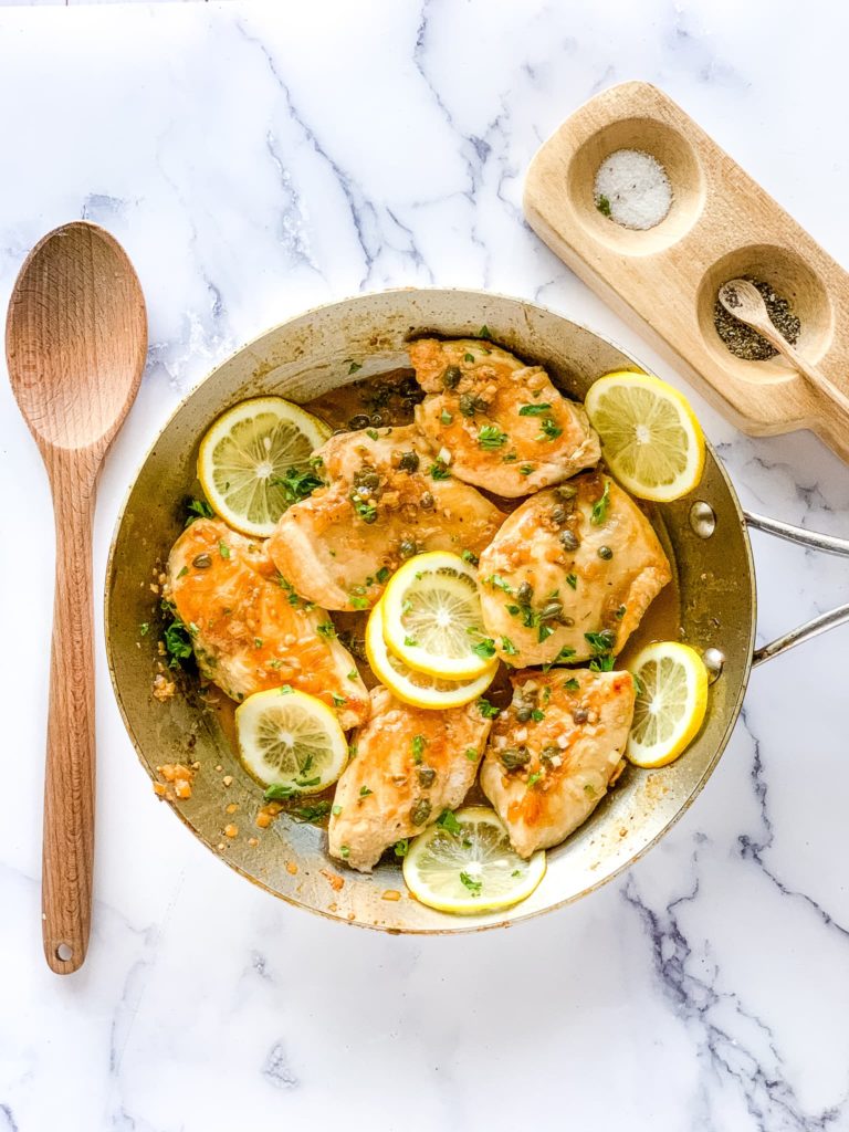 two chicken breasts in a stainless skillet for chicken piccata recipe