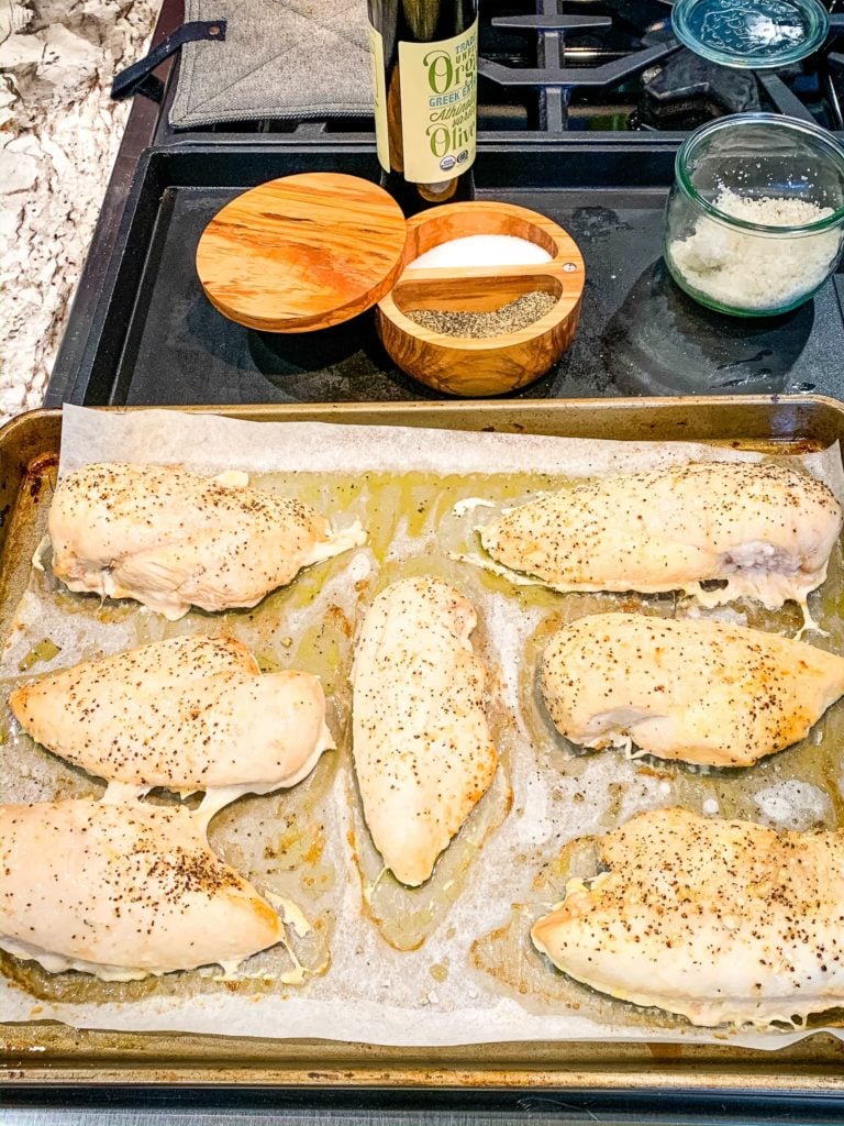 Baked pieces of boneless skinless breast meat on a baking sheet.