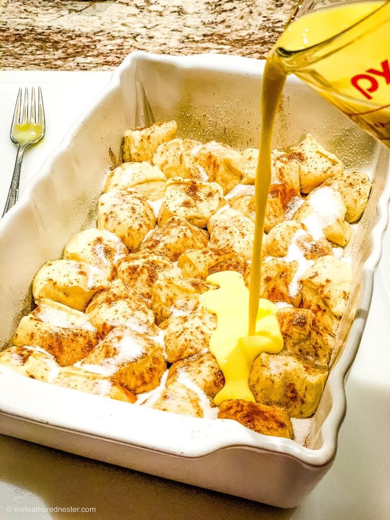 pouring the egg and milk mixture over overnight French Toast casserole