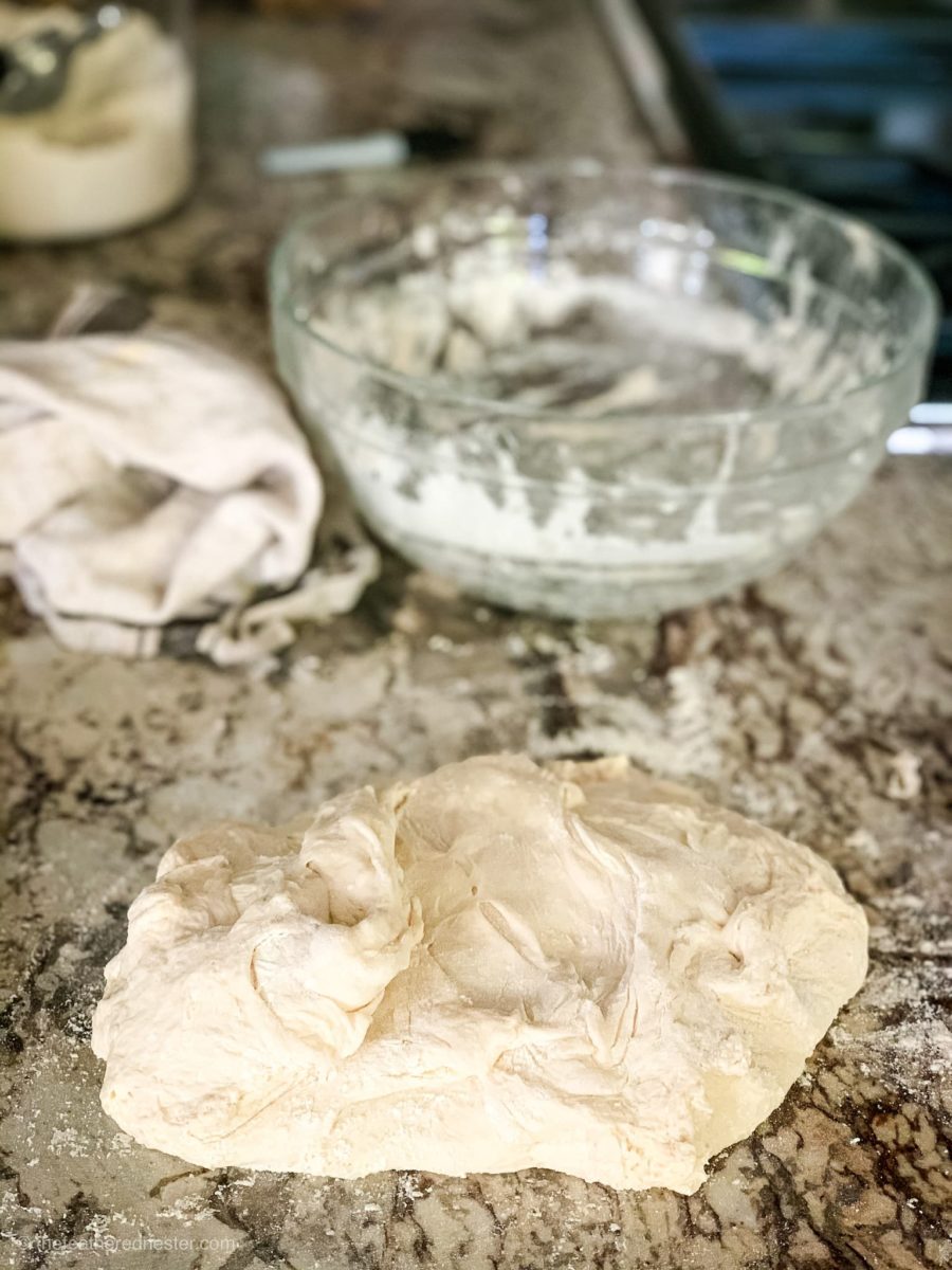 Folding dough on a marble counter top.
