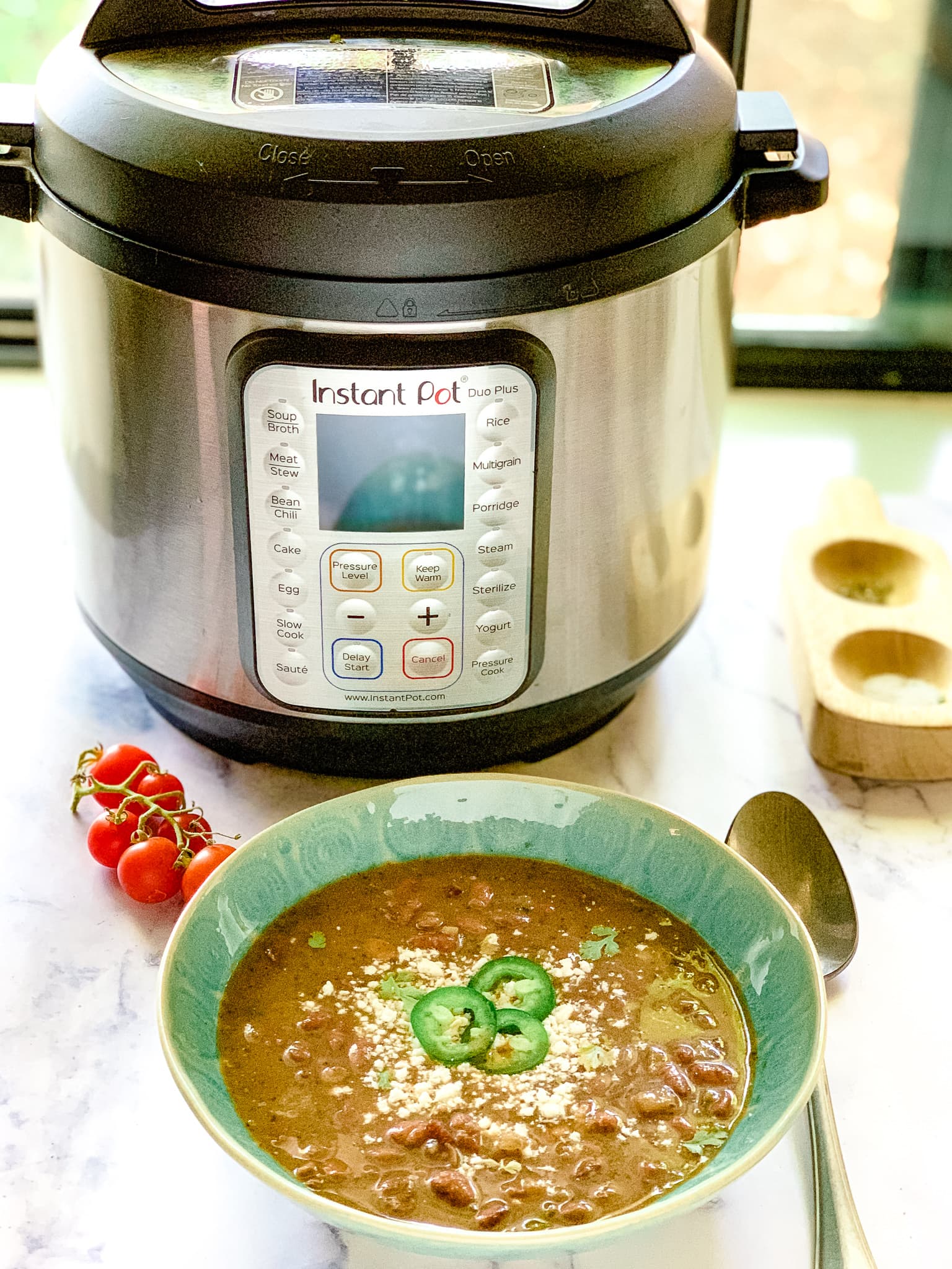 A green bowl of pinto beans made from this instant pot pinto beans recipe.