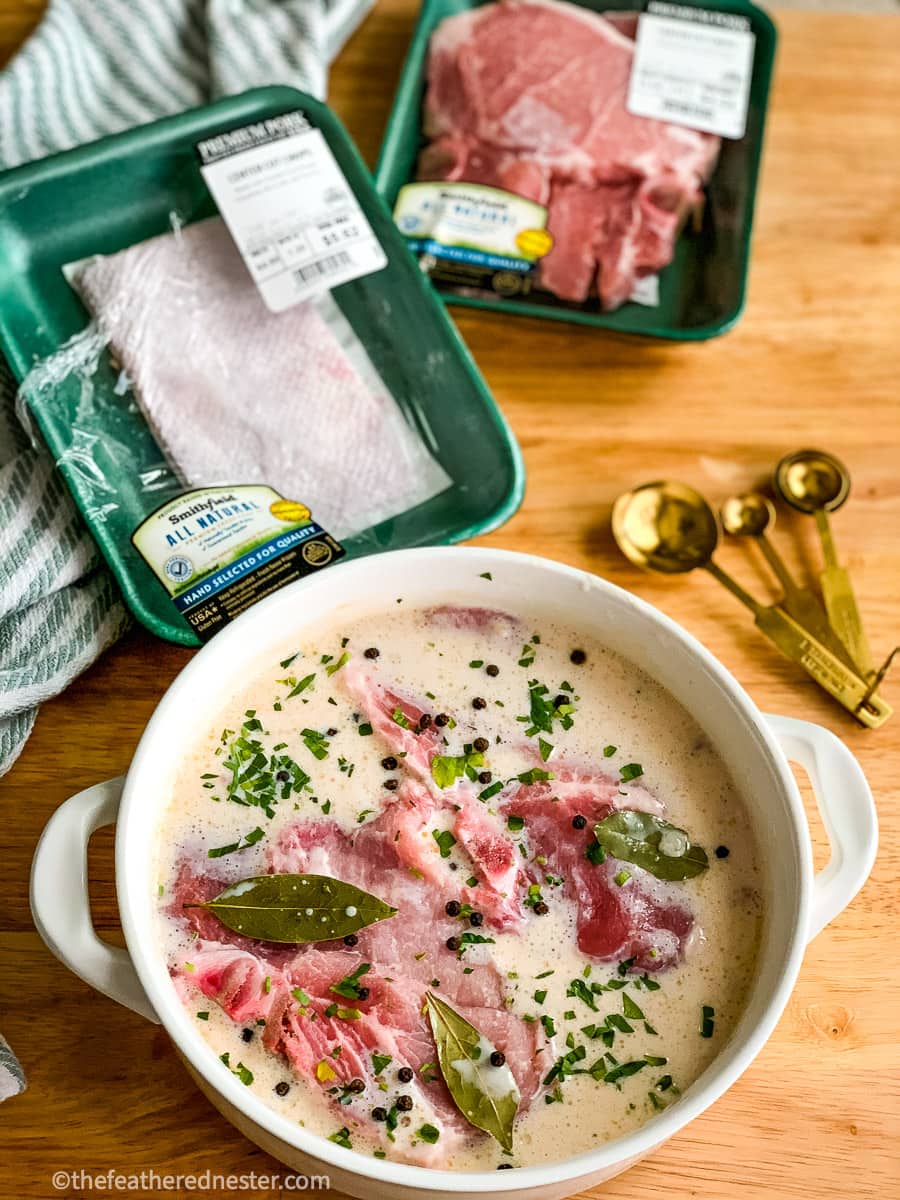 A shallow bowl of pork chops soaking in brine.