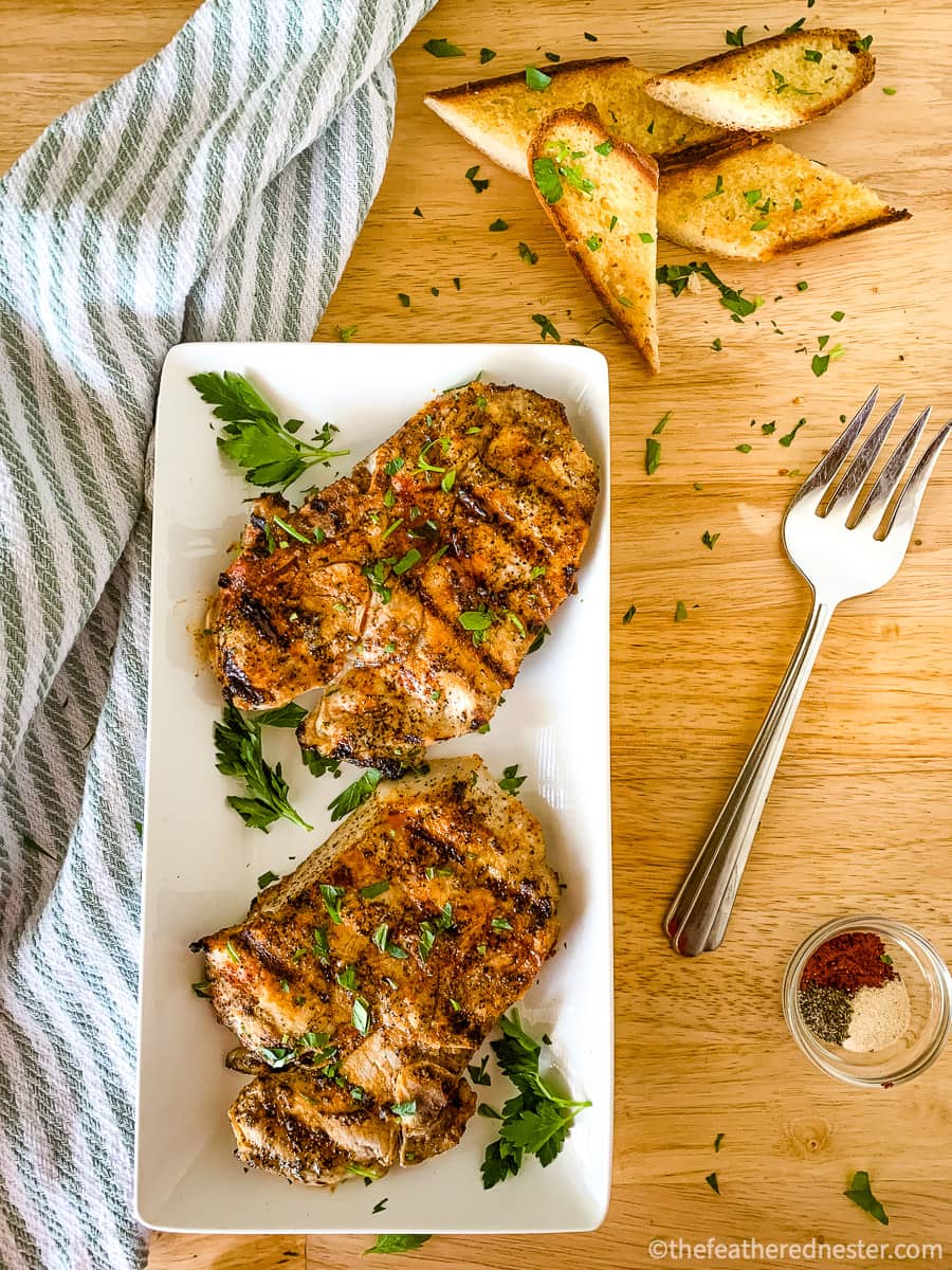 Cooked pork chops on a plate with garnish.