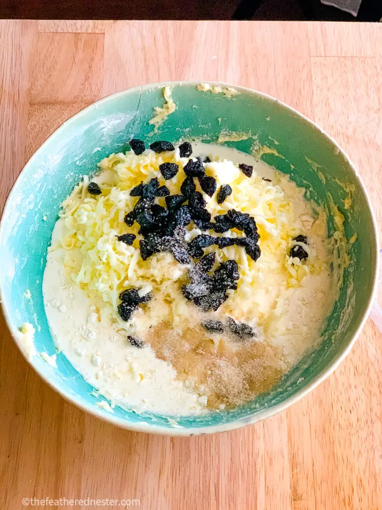 a green bowl of cream, nuts, dried fruit for scones