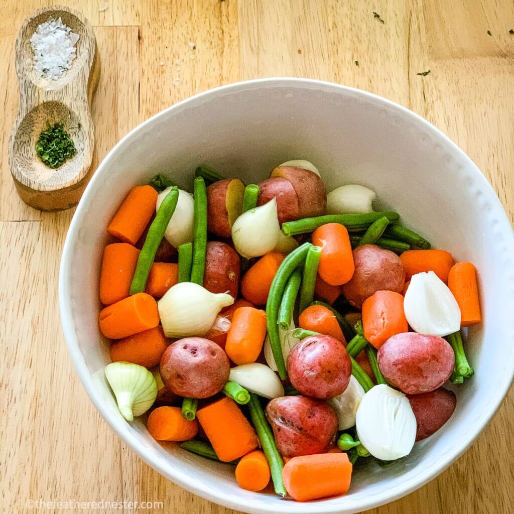 a bowl of carrots, potatoes, green beans, and onions ready for balsamic marinade