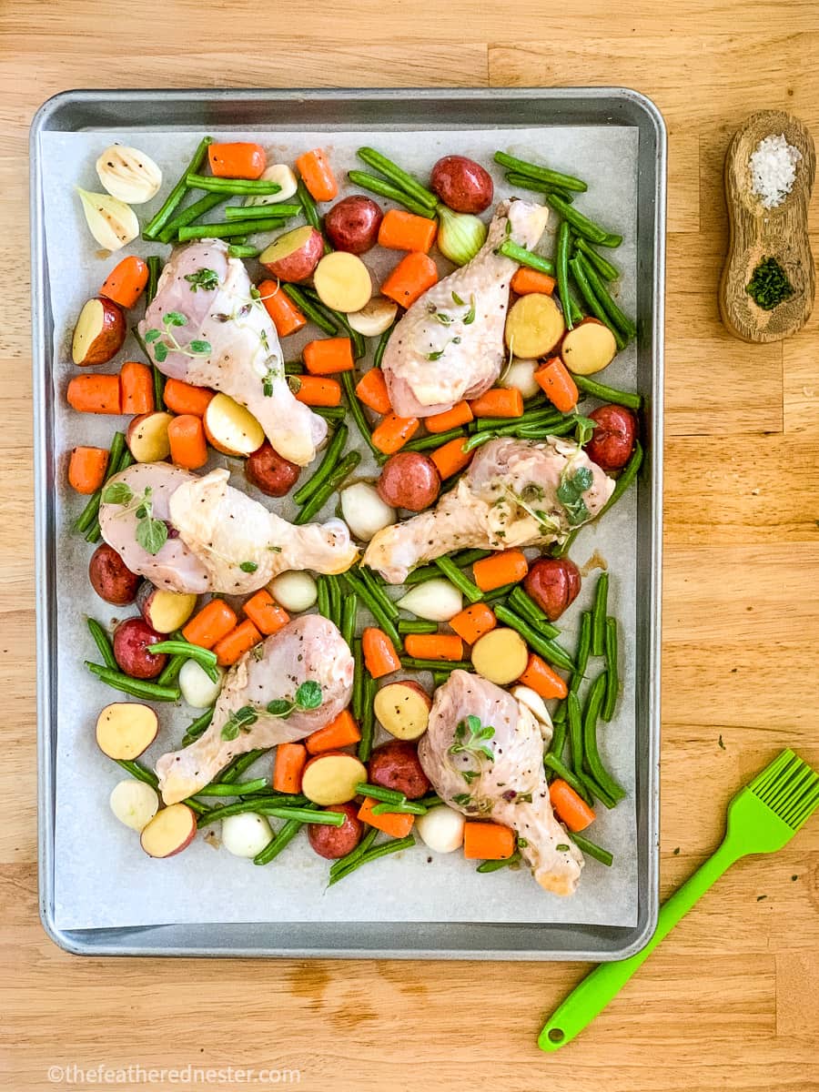 prepared one pan chicken drumsticks with potatoes and veggies ready to go into the oven