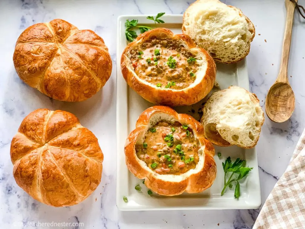 a serving platter of homemade Bread Bowls filled with Cheeseburger Soup