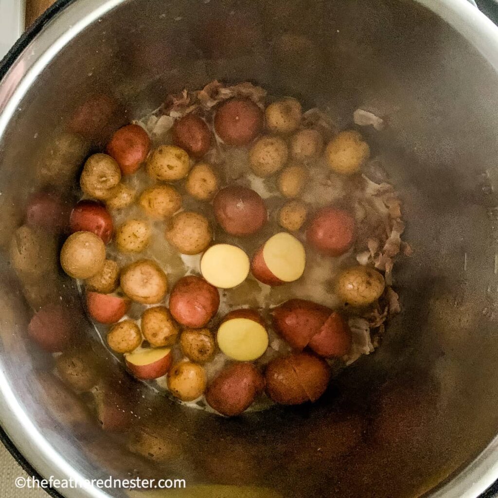 A pot showing Instant pot steamed red potatoes ready to pressure cook