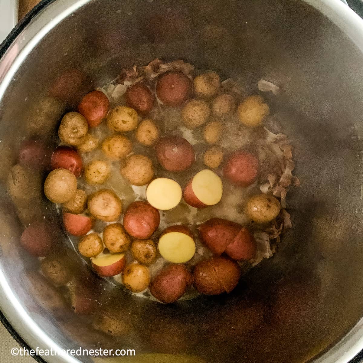 A pot showing Instant pot steamed red potatoes ready to pressure cook.