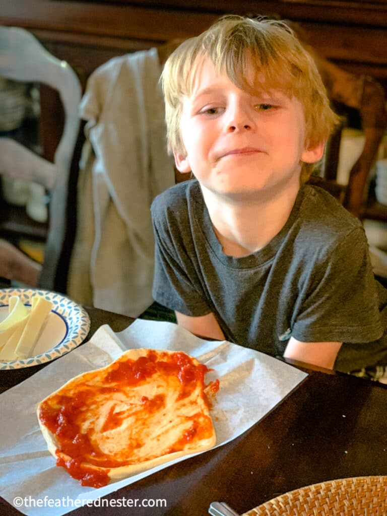 photo of child making a pizza