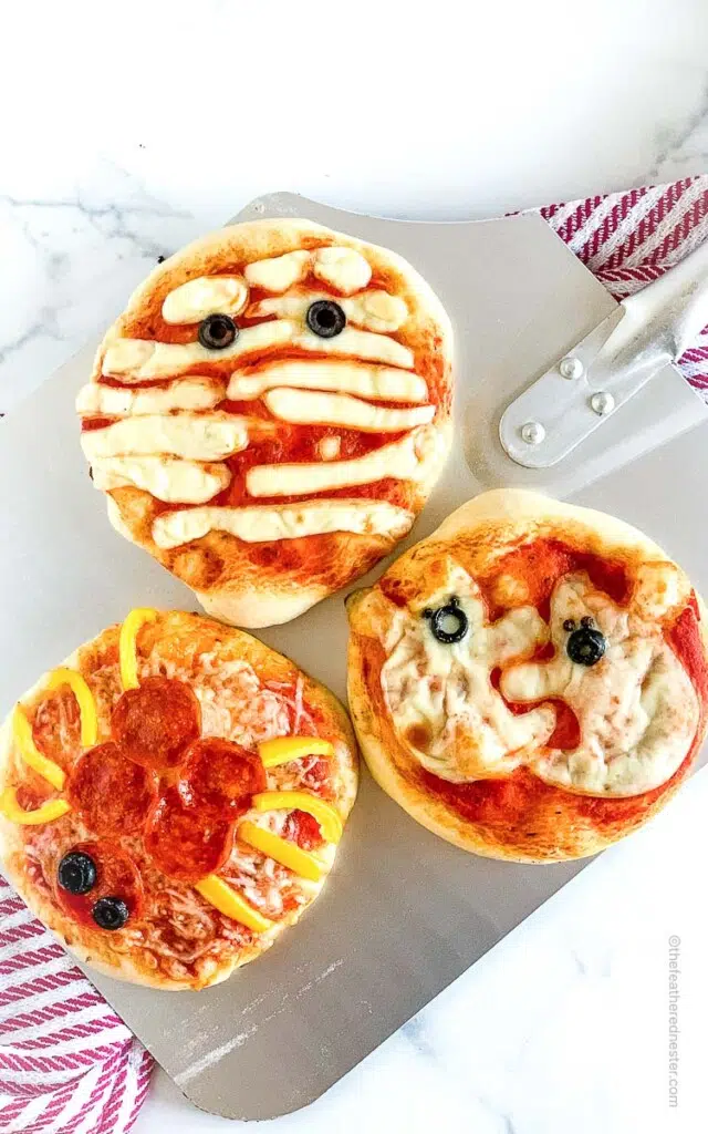 three halloween pizzas: mummy pizza, ghost pizza, spider pizza