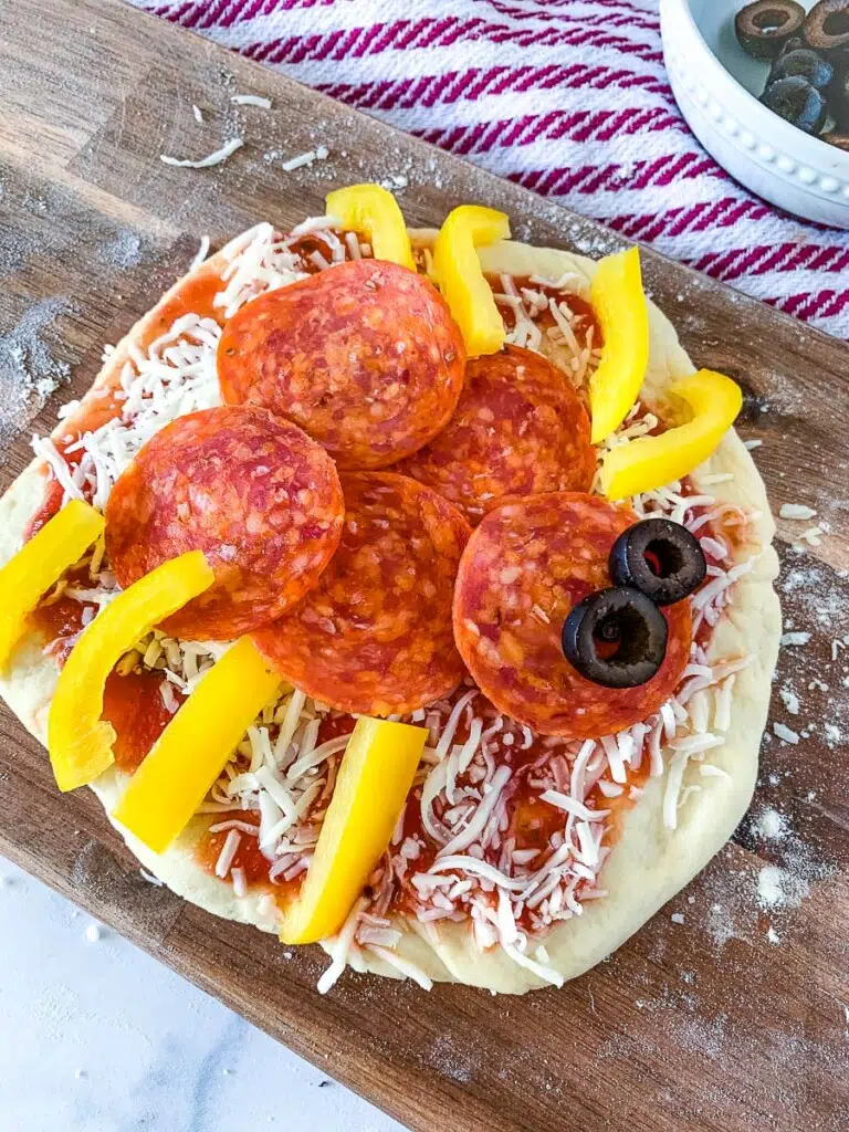 a Halloween mini pizza with pepperoni, bell pepper, and olives to look like a spider