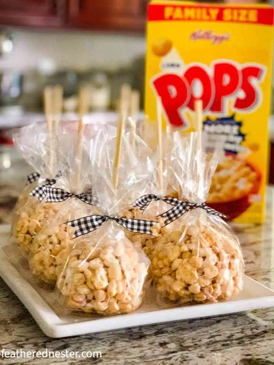 a platter of cellophane wrapped corn pop treats tied with black and white ribbon and a box of Corn Pops cereal in the background