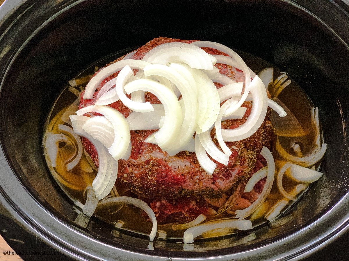 seasoned beef roast with a crock pot and McCormick all purpose seasoning in the background