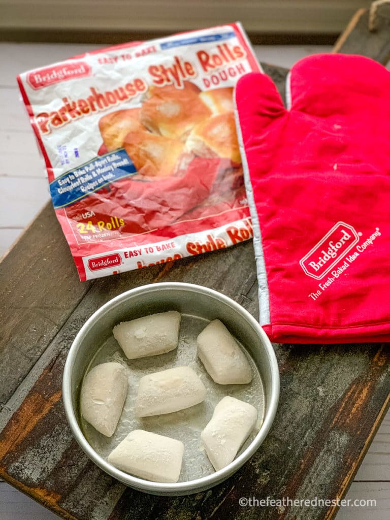 frozen dinner rolls in pan to thaw with bag of Bridgford parker house rolls in the background