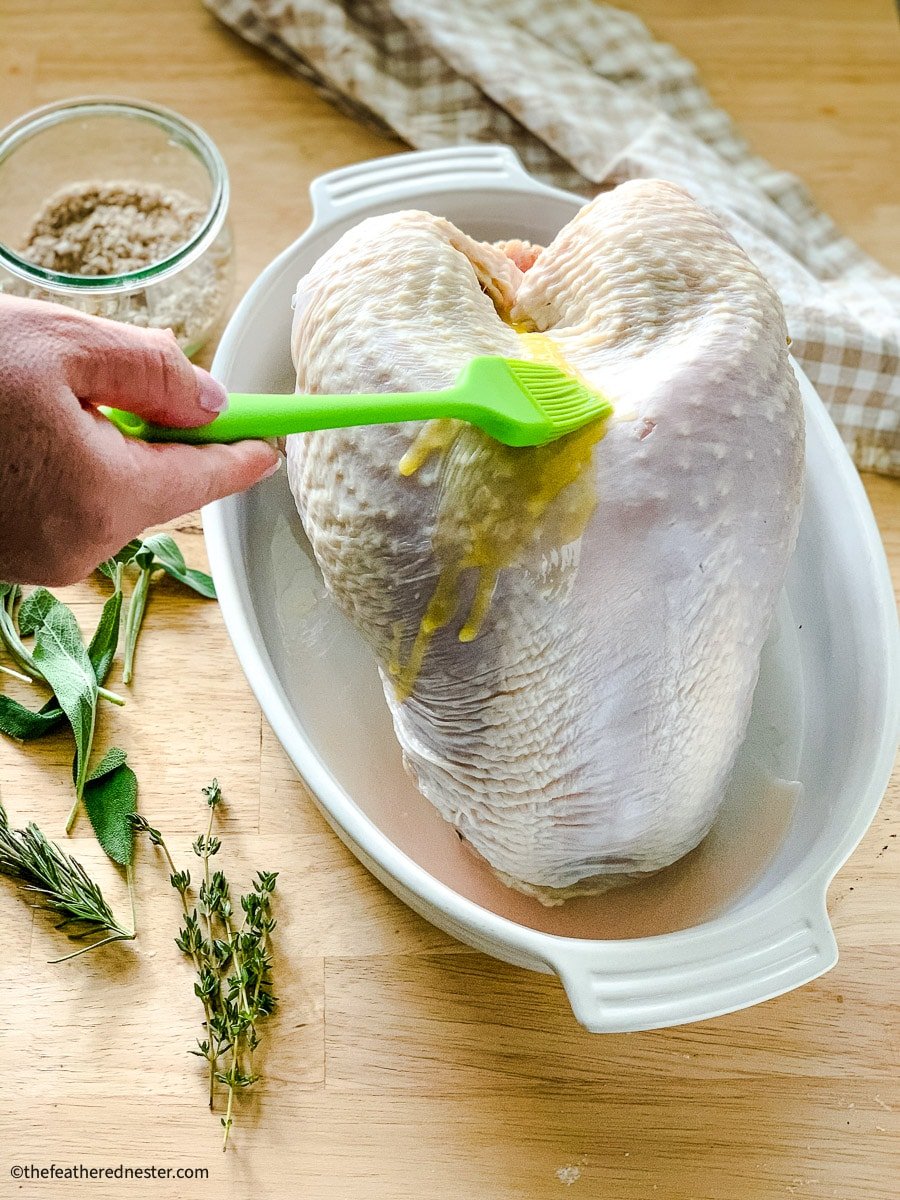 Brushing melted butter over the skin of uncooked poultry.