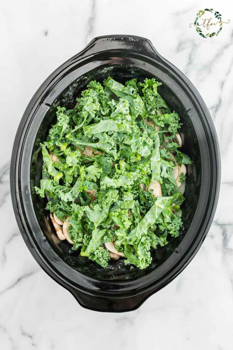 Crockpot filled with chicken and kale. 