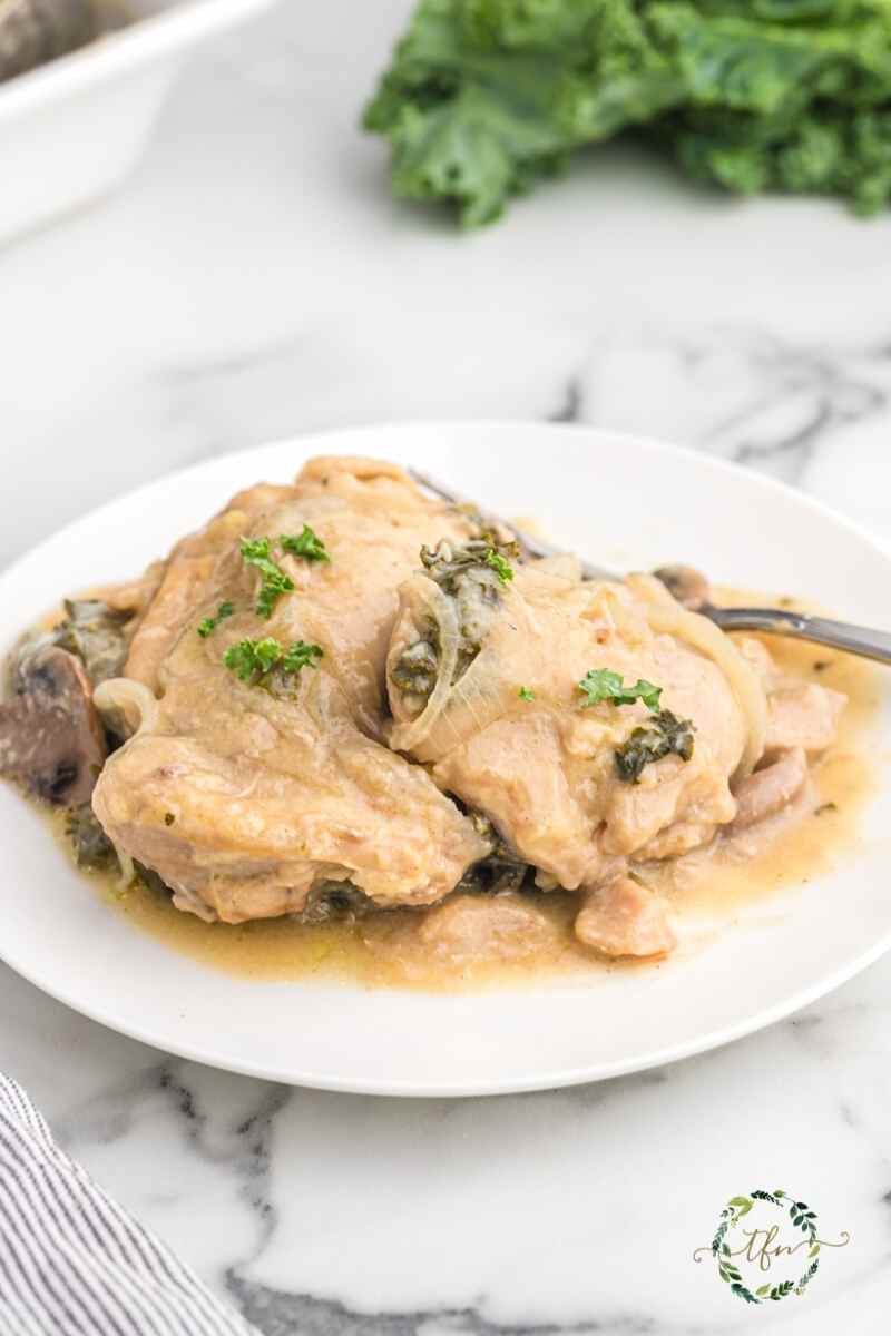 Crockpot creamy smothered chicken on a white plate.