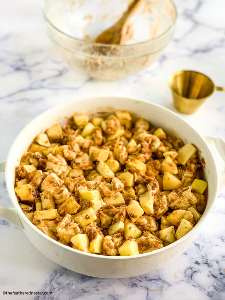 chopped dough and apples in a casserole dish 