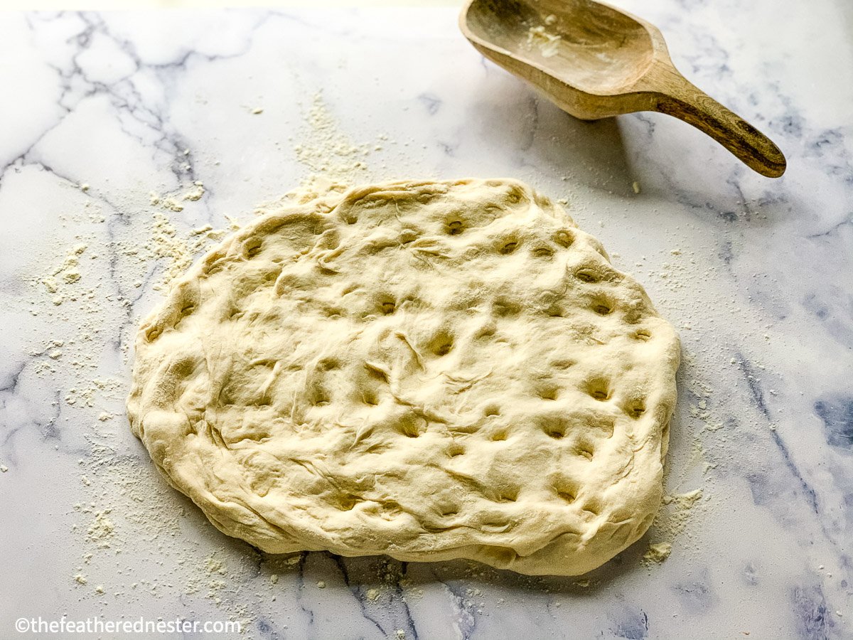 Finger dimples on a disc of dough.