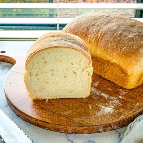 fresh sourdough sandwich bread on top of a wooden board.