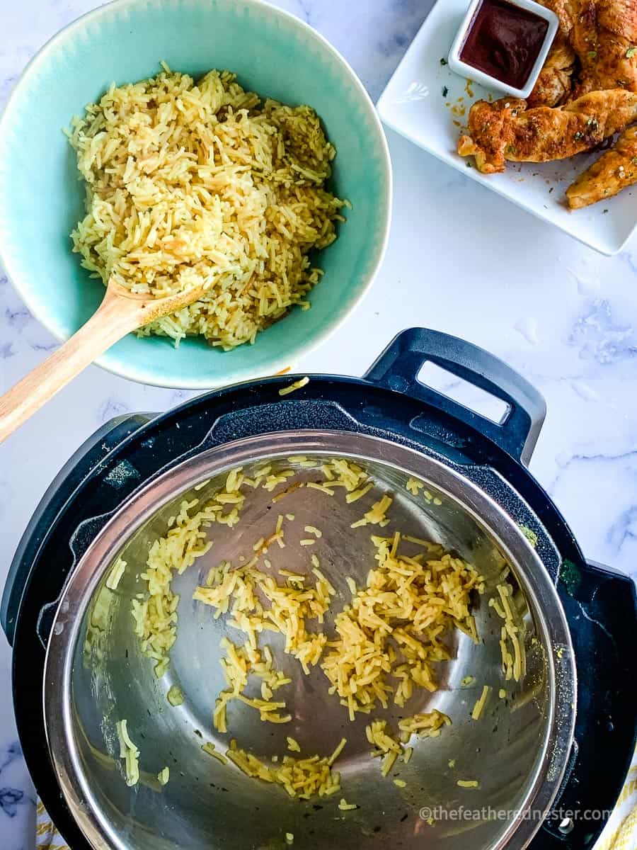 Transferring the rice from the Instant Pot to the green bowl with a wooden spoon. 