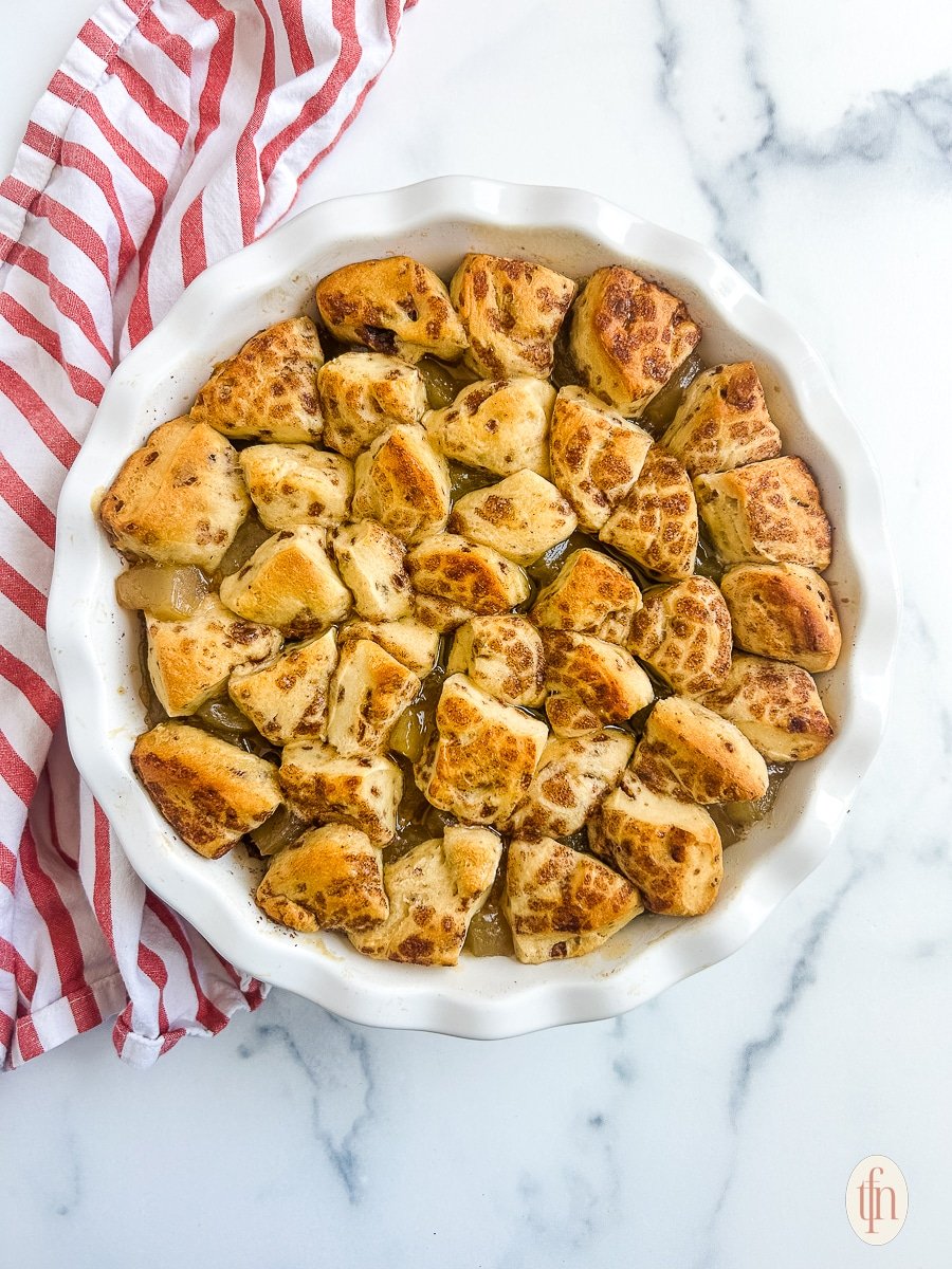 Baked cinnamon rolls with apple pie filling on a white background. 