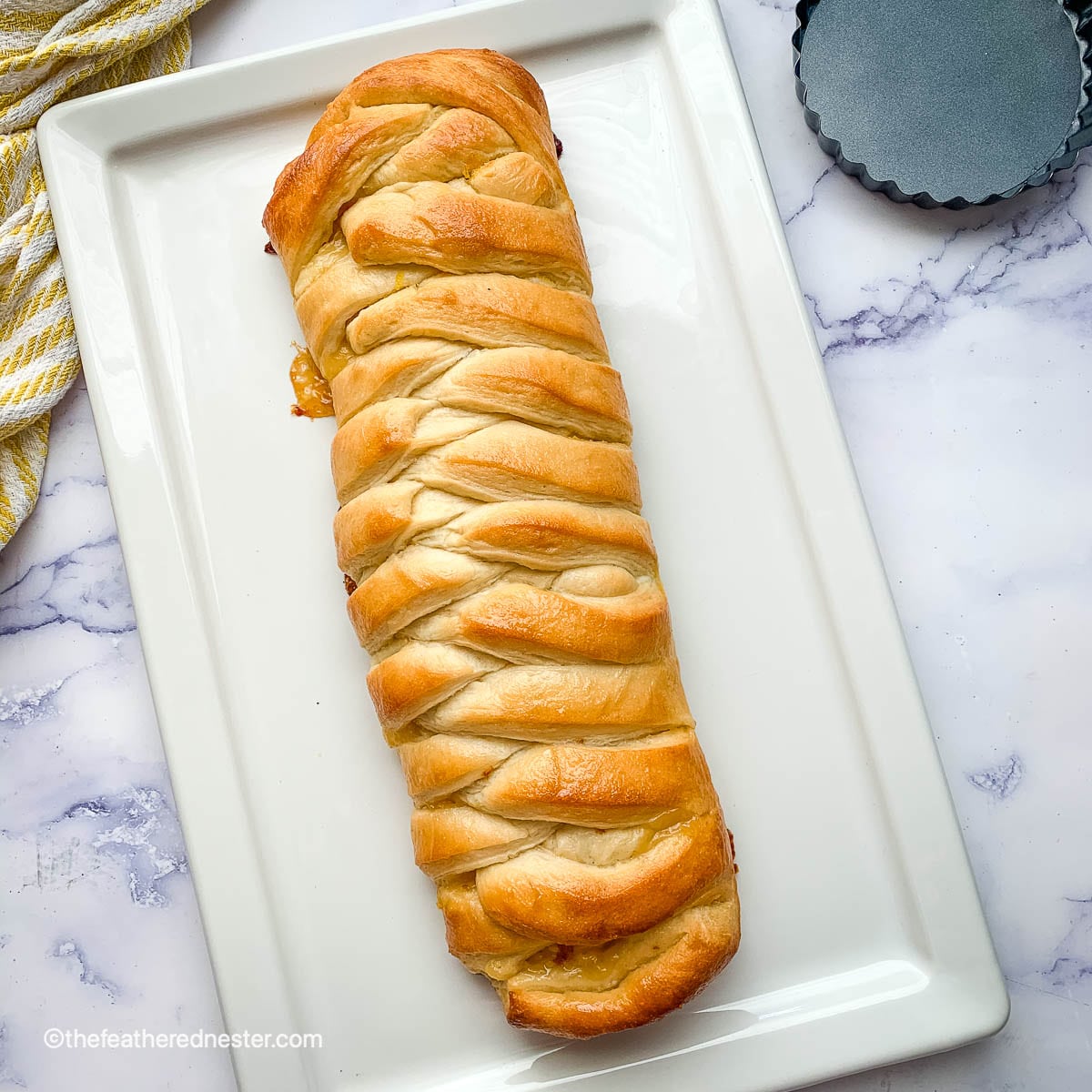 lemon braided bread loaf on a white platter.