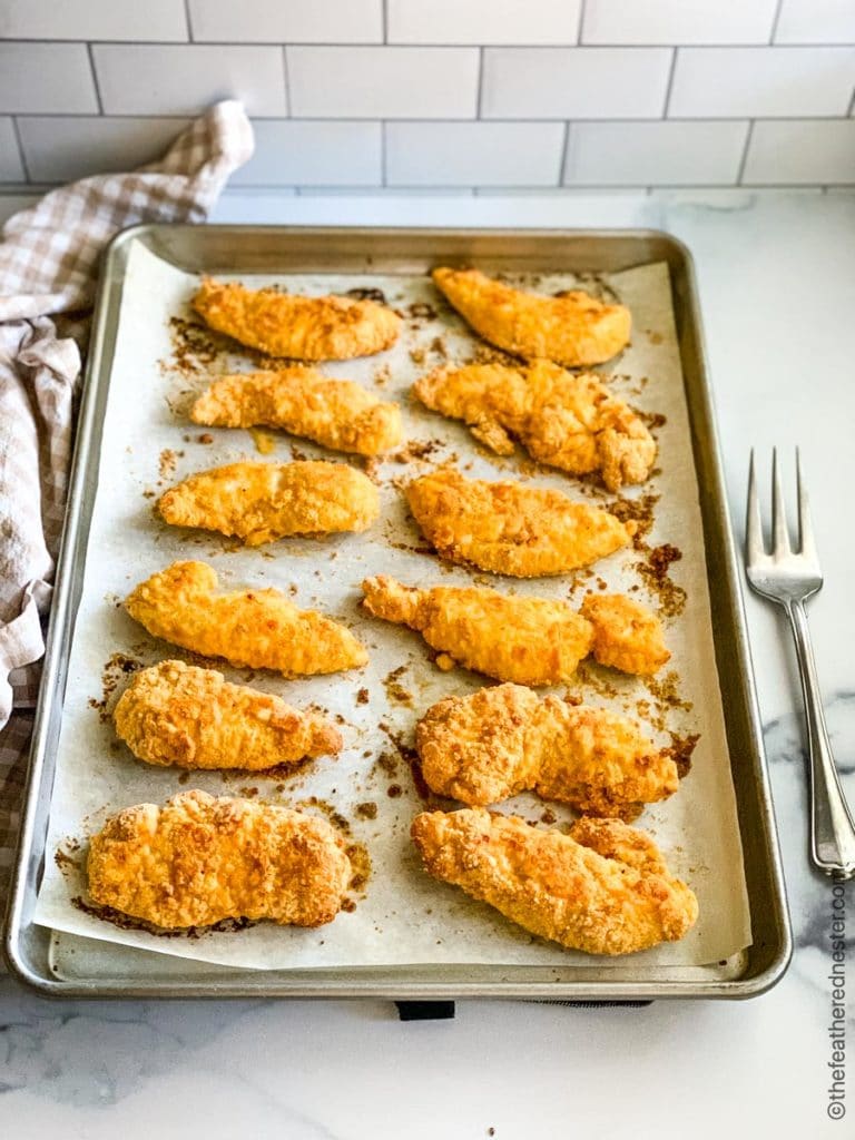 a tray of baked chicken tenderloins ready to serve