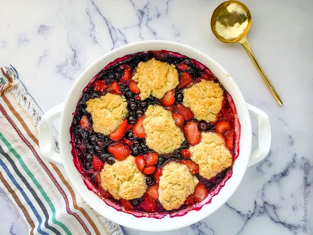 a fruit cobbler with strawberries and blueberries with biscuit topping